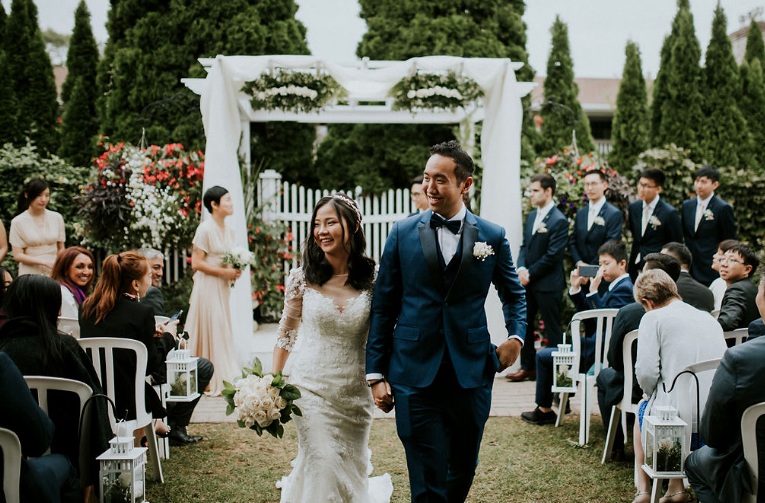 Bride and groom walking down an outdoor wedding aisle