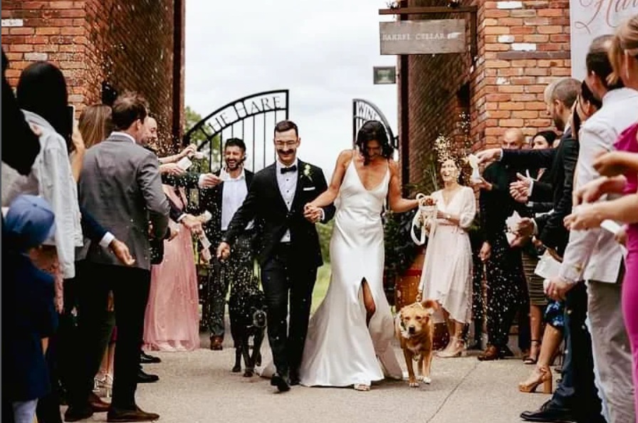 Wedding couple celebrating with guests outside a brick building
